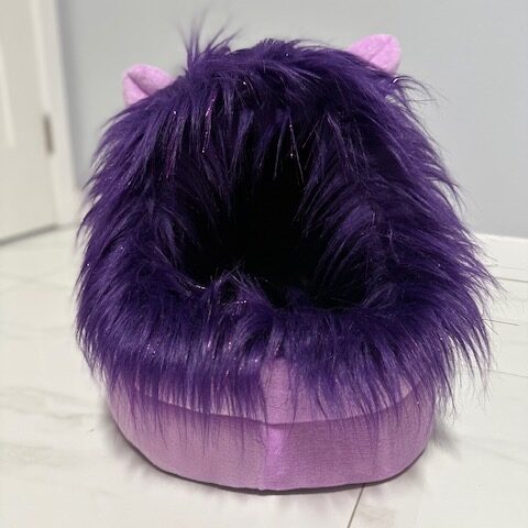 A purple furry slipper with a shiny base.