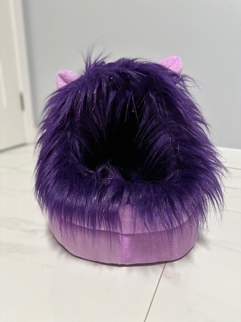 A fuzzy purple slipper with a shiny base.