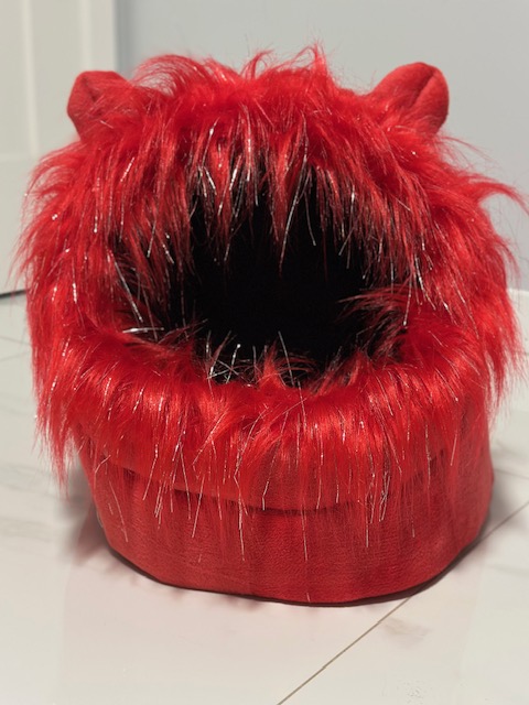 A red furry monster mouth with sharp teeth and a black interior.